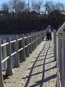A wheelchair user using the improved boardwalk and enjoying views of the water in Yorkton, Saskatchewan.