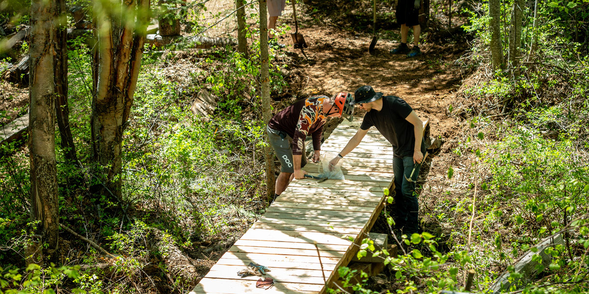 Trail operators repair a boardwalk section along a trail.