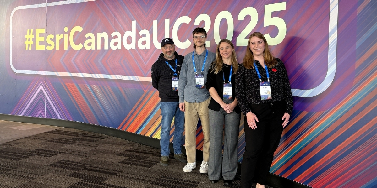 group of people standing infront of a buildboard smiling