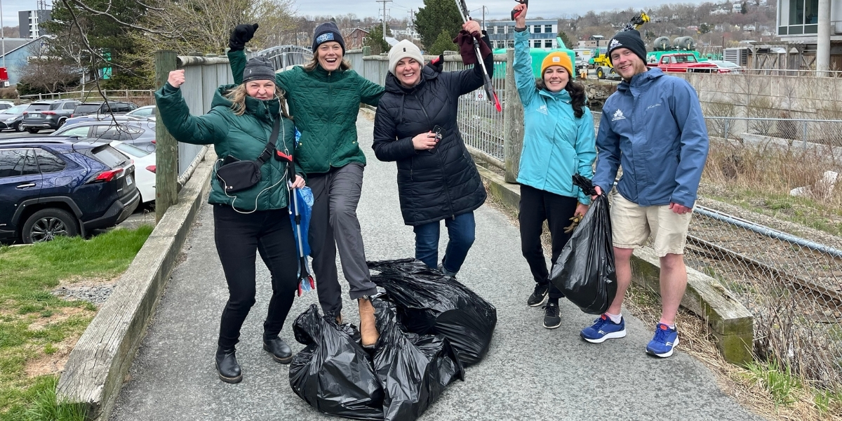 group of people picking up garbage on a cloudy day