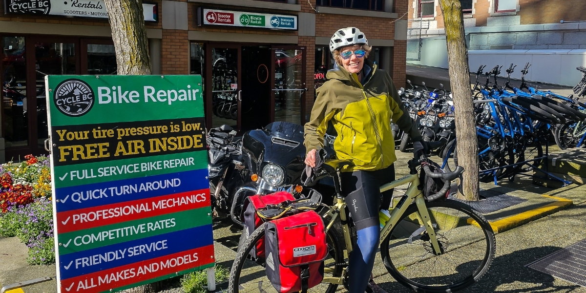 woman in front of signage posing with bikes