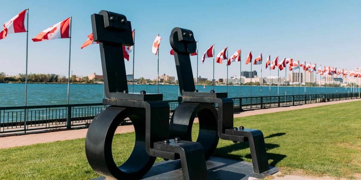 statues waterfront with canadian flags behind