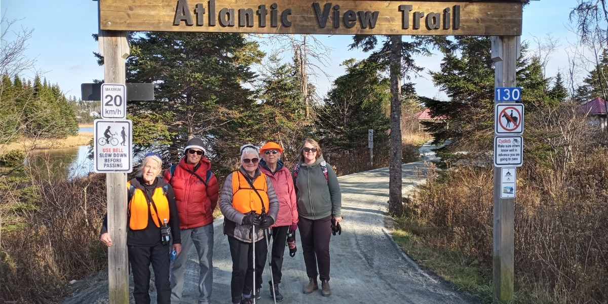 00Feature image_NS_Atlantic View Trail_Lost Soles_credit Lost Soles | Trans Canada Trail A group of hikers standing under an Atlantic View Trail sigh